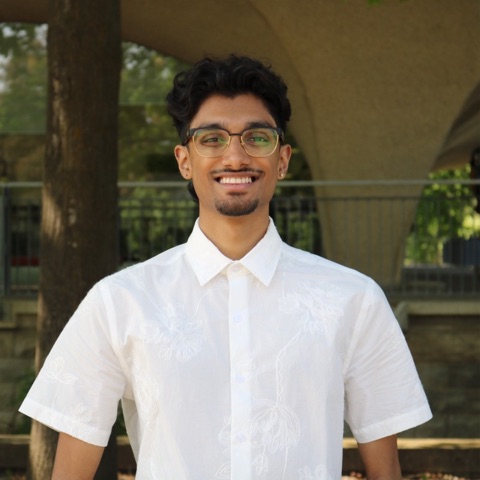 Portrait of Minal Patel, smiling, outdoors in a white shirt.